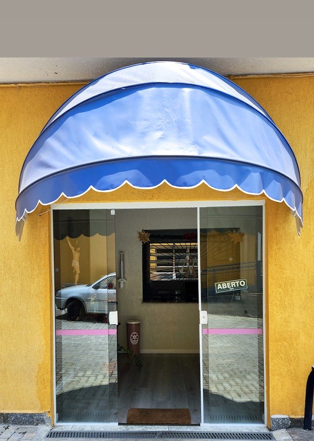 Toldo capota azul instalado em fachada comercial — obra São José Exteriores