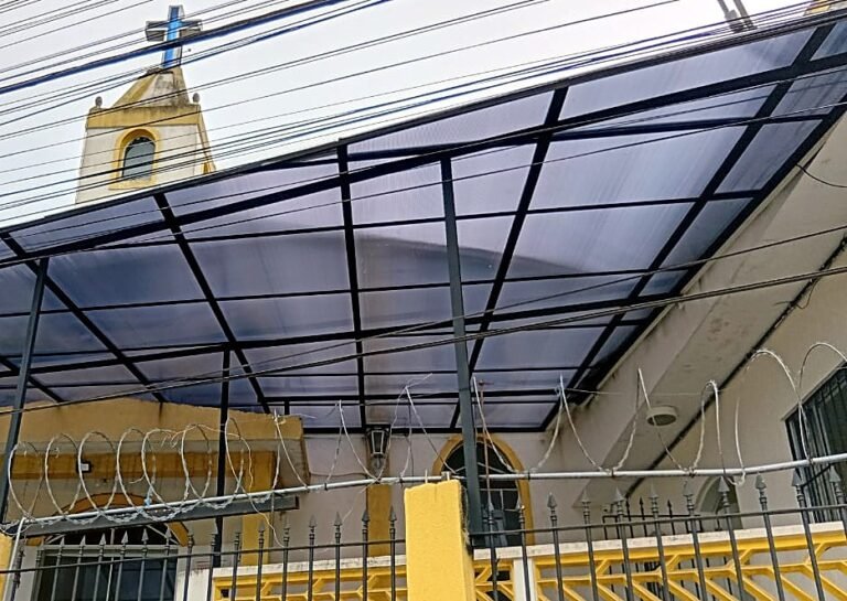 Cobertura em policarbonato com estrutura metálica sobre a entrada de uma igreja